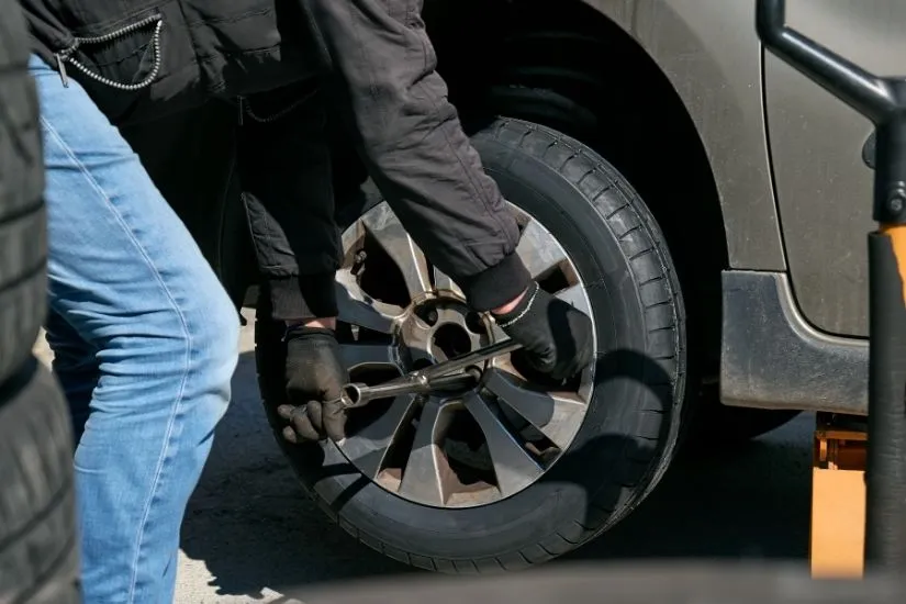 Dc auto care's mechanic performing on-site tire replacement