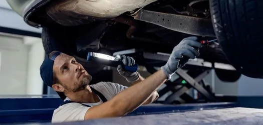 mechanic performing suspension repair of a car in minneapolis