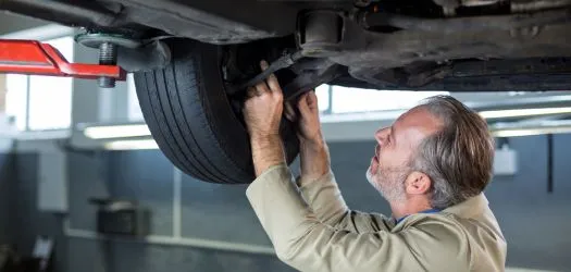 mechanic performing suspension repair of a car in minneapolis